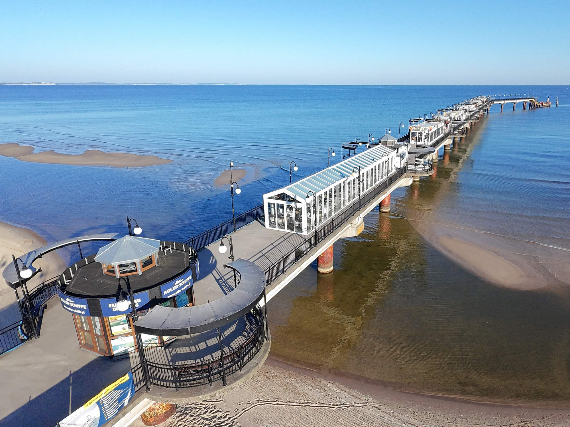 Molo w Międzyzdrojach obok nowoczesnego i luksusowego hotelu w pierwszej linii brzegowej na plaży z frontowym widokiem na morze